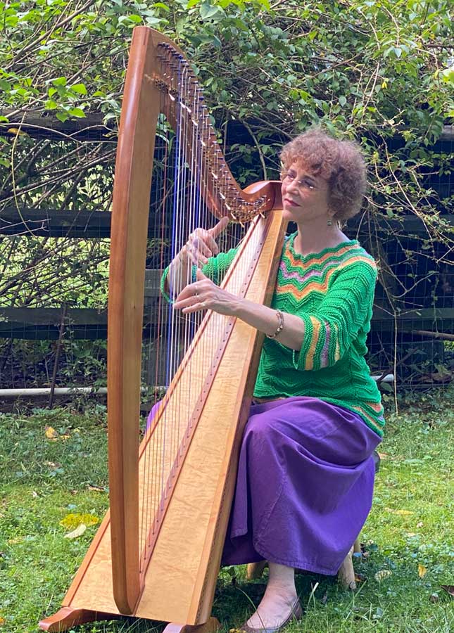 Anne seated, playing harp.